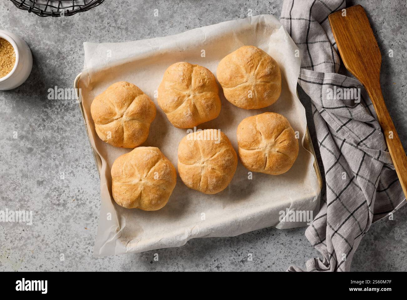 freshly baked bread buns on baking paper, top view Stock Photo
