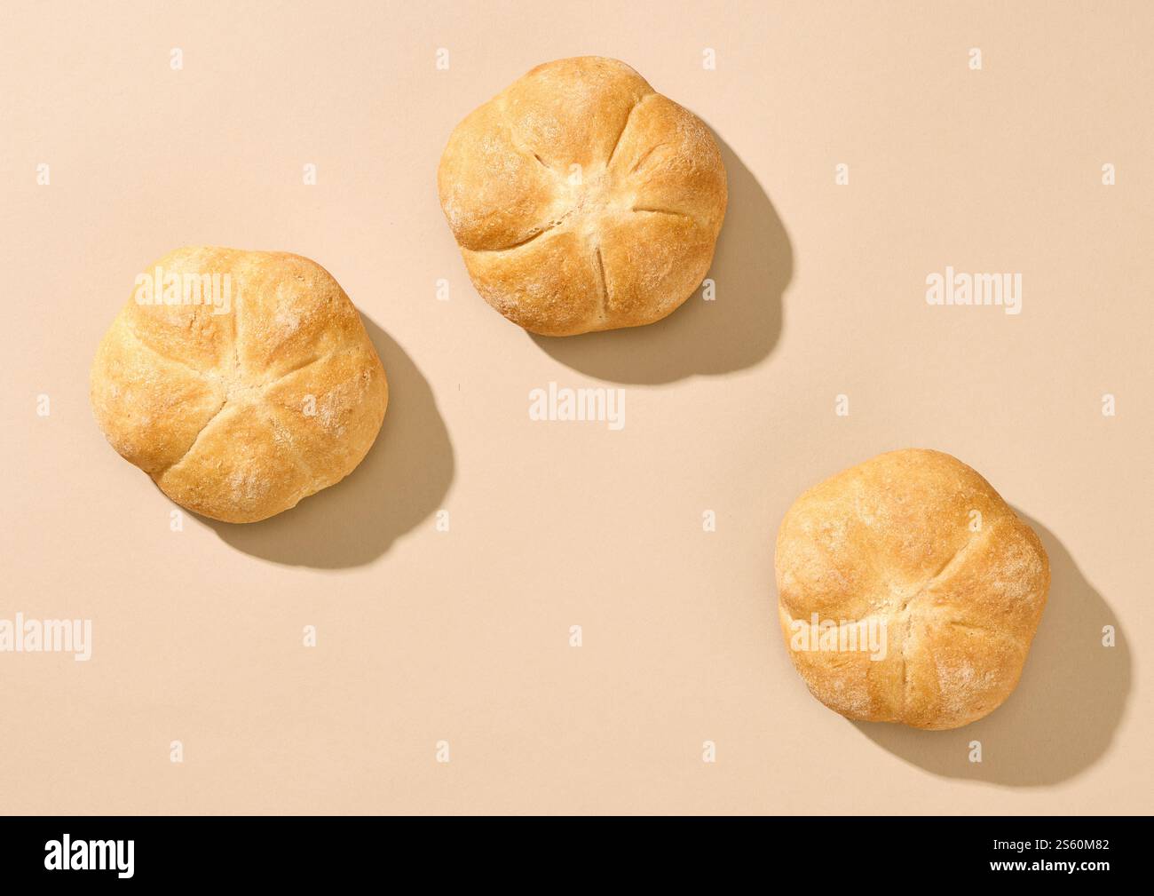 freshly baked bread buns on beige background, top view Stock Photo