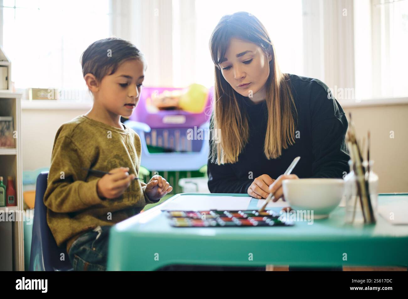 Painting, education and art with teacher and child in classroom for ...