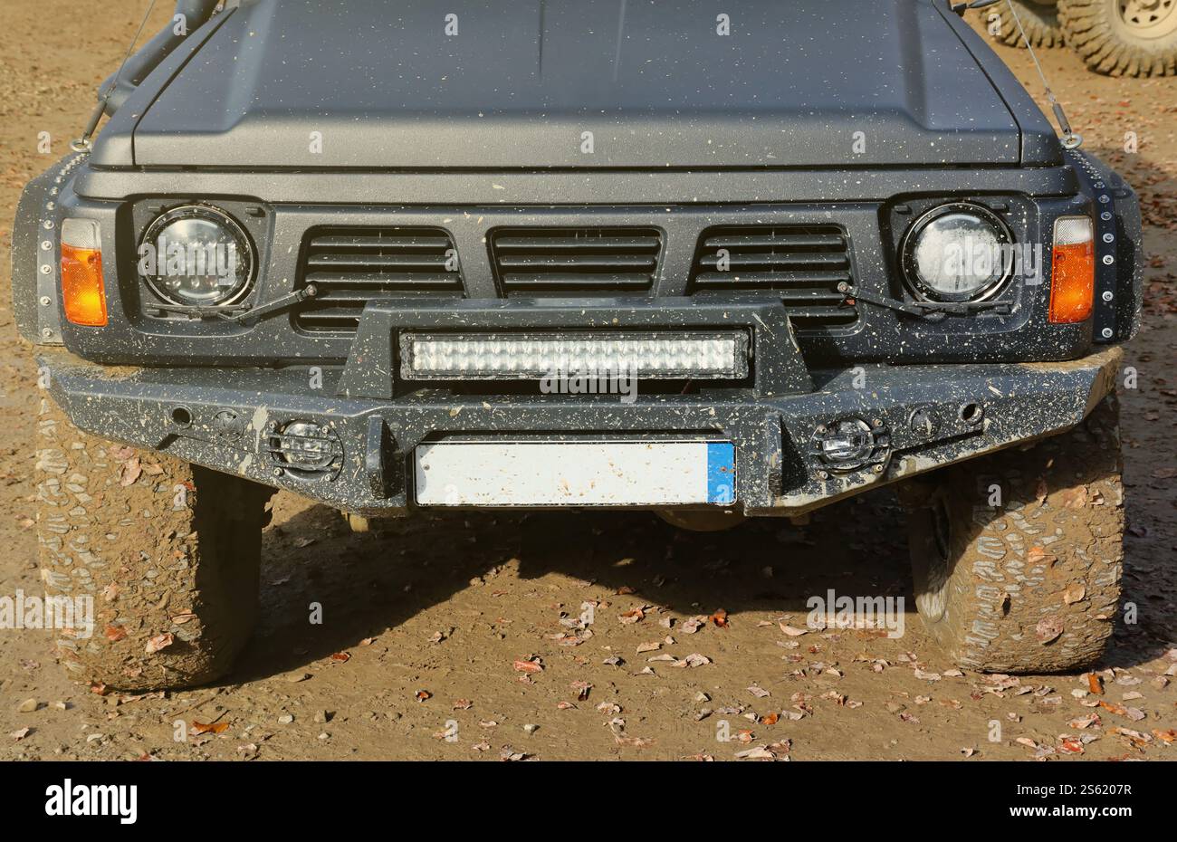 Automobile in a countryside landscape with a mud road. Off-road 4x4 suv automobile with ditry body after drive in muddy road area. Automobile in a Stock Photo