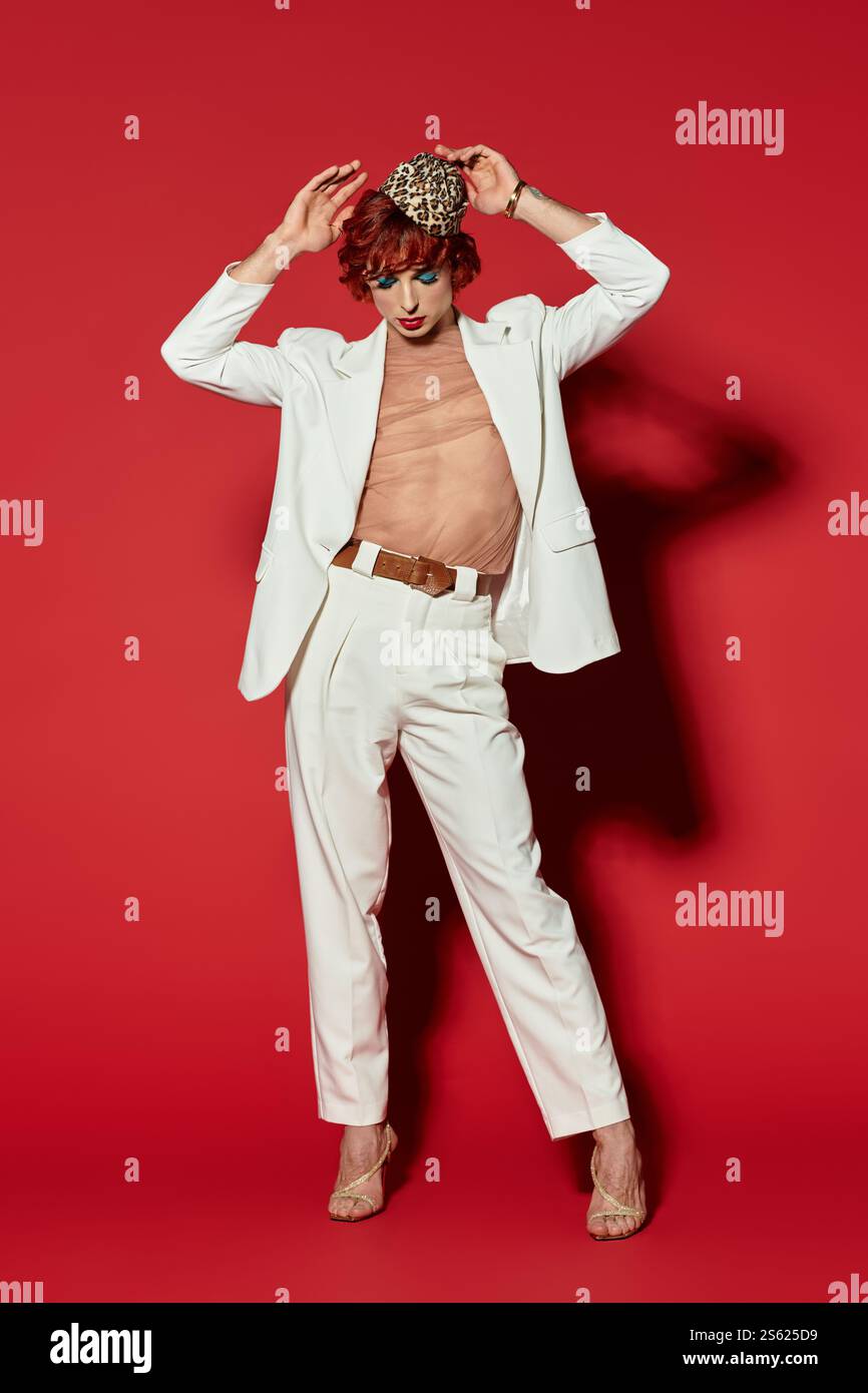 This young man confidently poses in a white suit and striking makeup ...