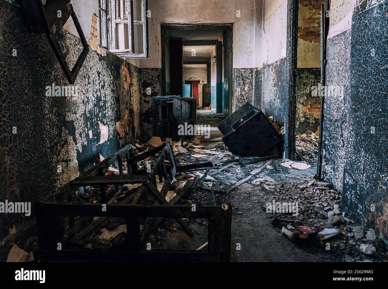 Ravaged Building Abandoned corridor with charred debris, burnt walls, broken window ...