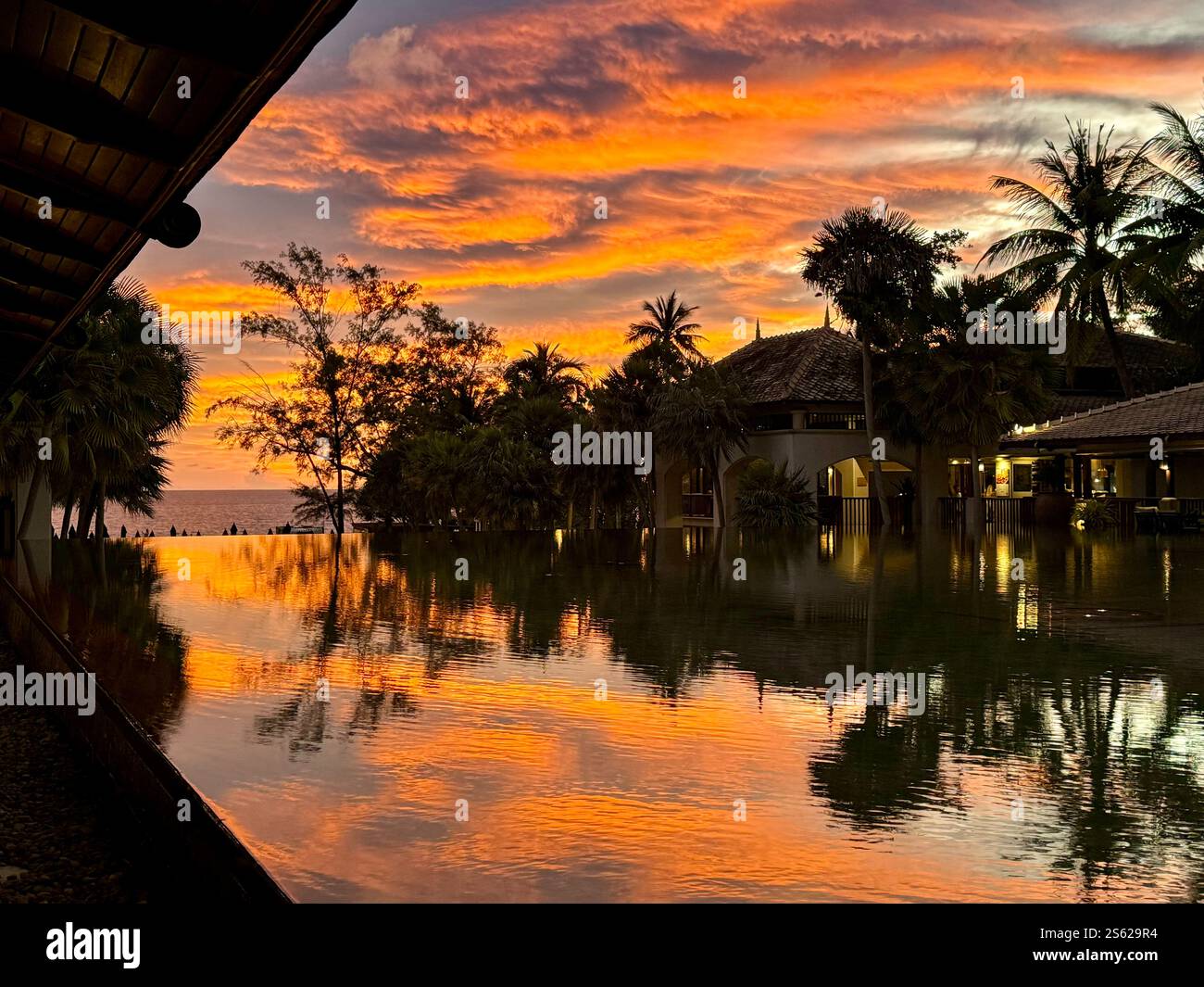 Dramatic sunset over water feature in Phuket, Thailand. Dramatic colors lighting up the sky - Smartphone Captured Stock Image
