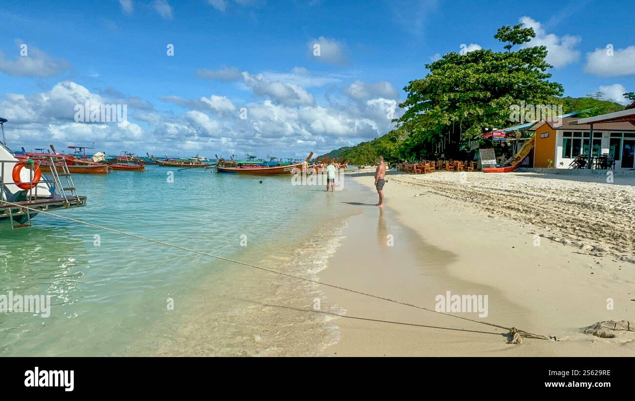 People walking on the beach of Phi Phi Island, Thailand with blue sky and small clouds - Smartphone Captured Stock Image