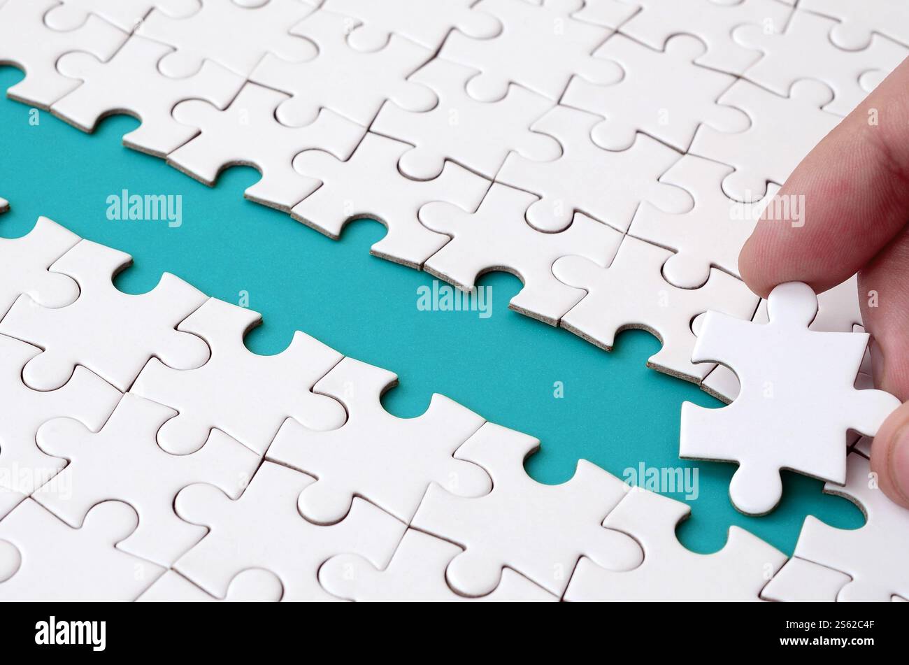 The human hand paves the way to the surface of the jigsaw puzzle The human hand paves the way to the surface of the jigsaw puzzle