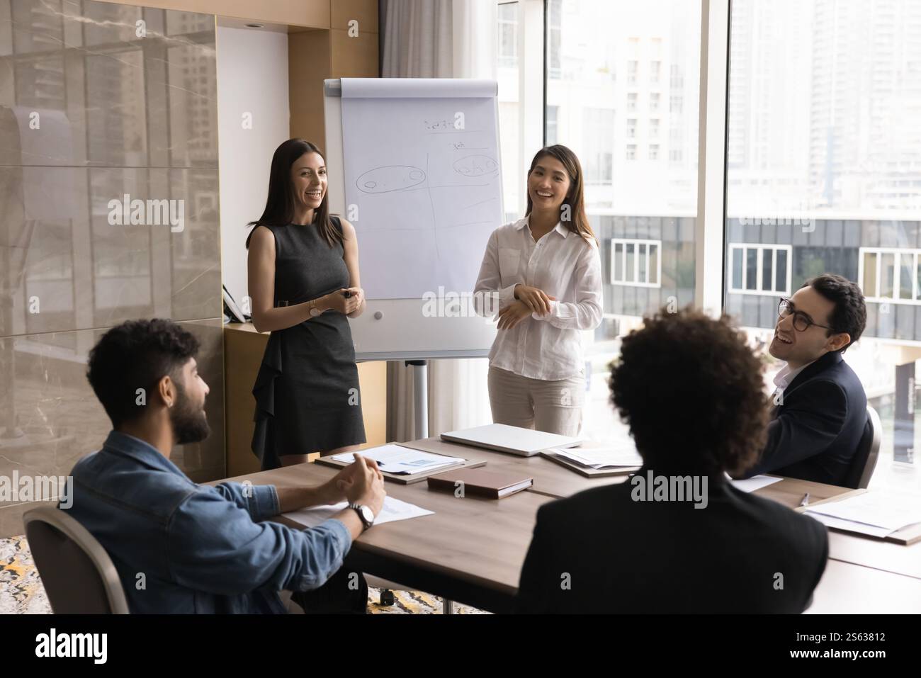 Two young multiethnic trainers hold corporate training event for staff Stock Photo