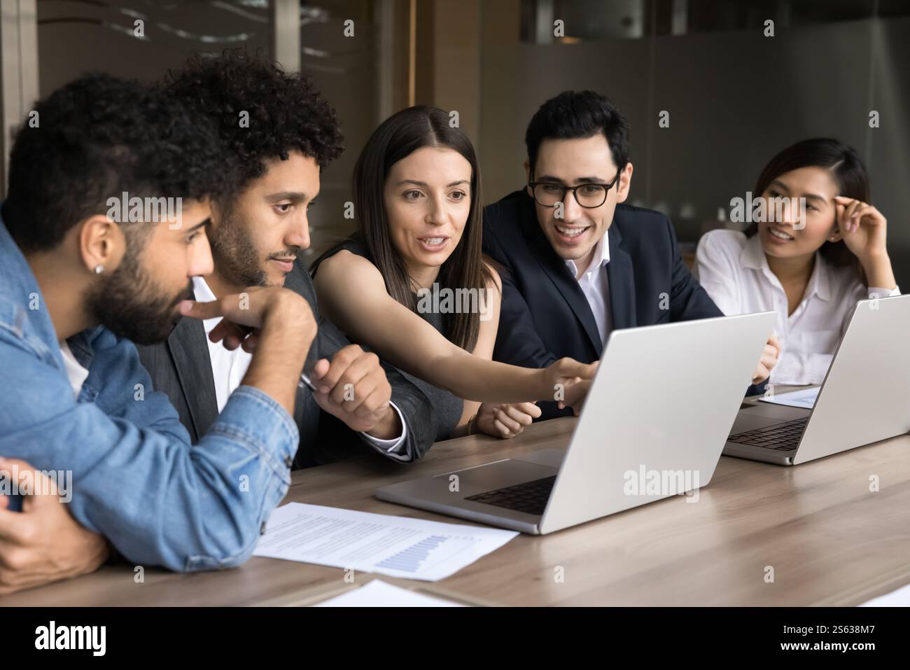 Group of professionals working together on joint task using laptops Stock Photo