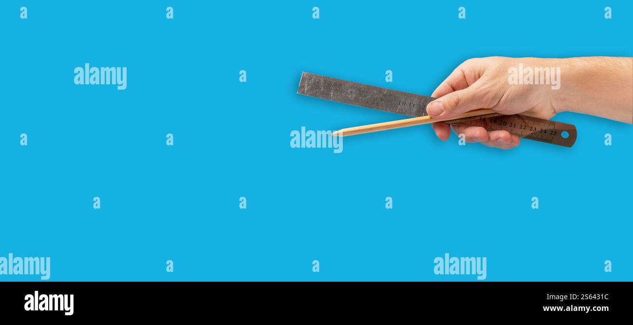 Ruler and pencil in hand on blue background Stock Photo