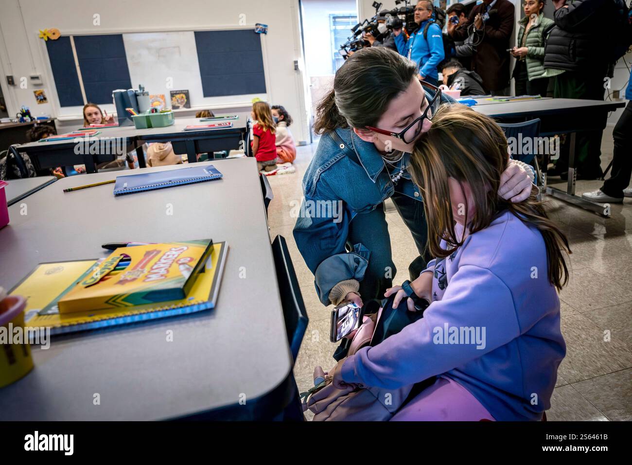 A mother kisses her child goodbye on the first day back to school at