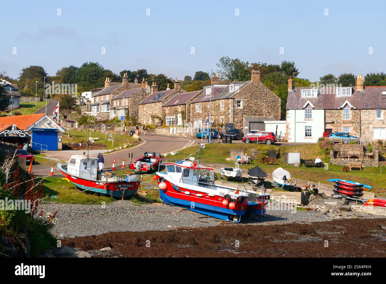 fishing boats in craster harbour at low tide in traditional fishing ...