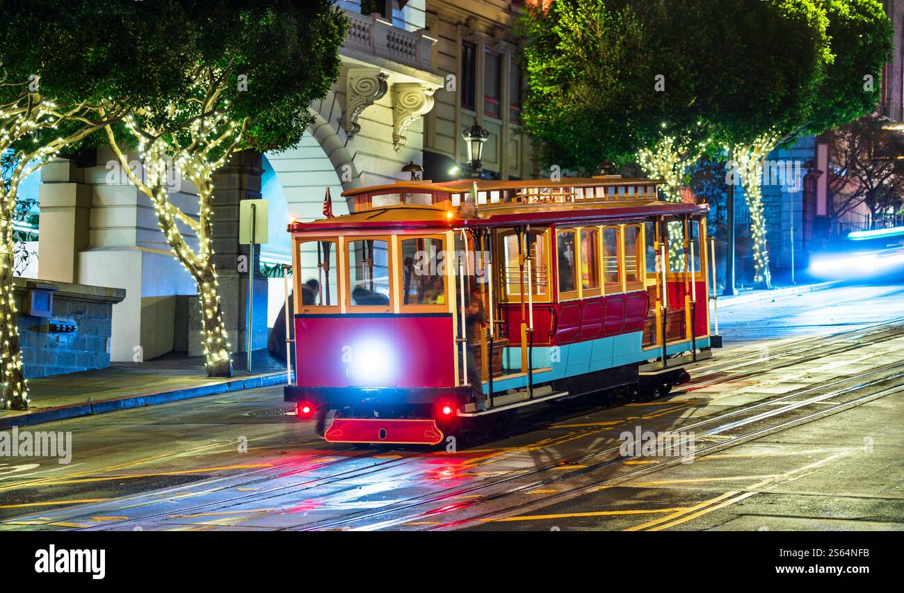 Iconic San Francisco cable car illuminated at night at the intersection ...