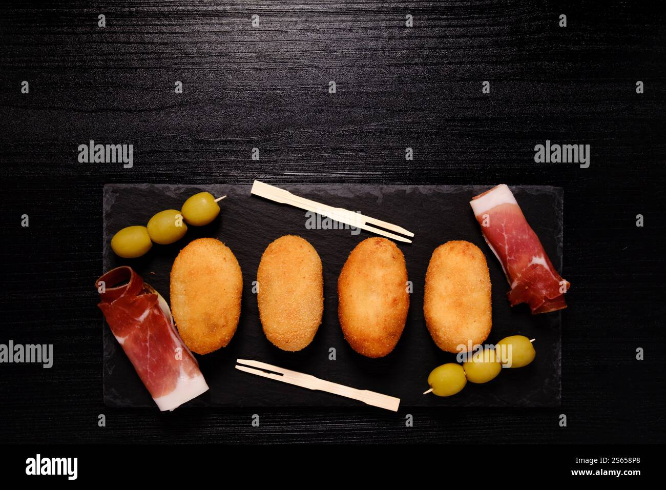 Croquettes with ham on rectangular slate plate with negative space on top Stock Photo