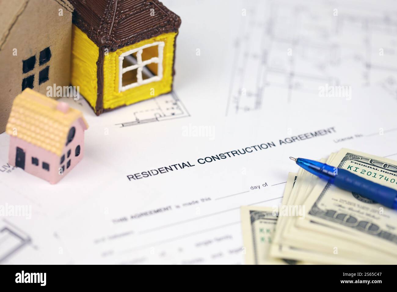 Residential construction agreement ready to sign with small toy houses and pen. Construction contract. Permission to build. Residential construction Stock Photo