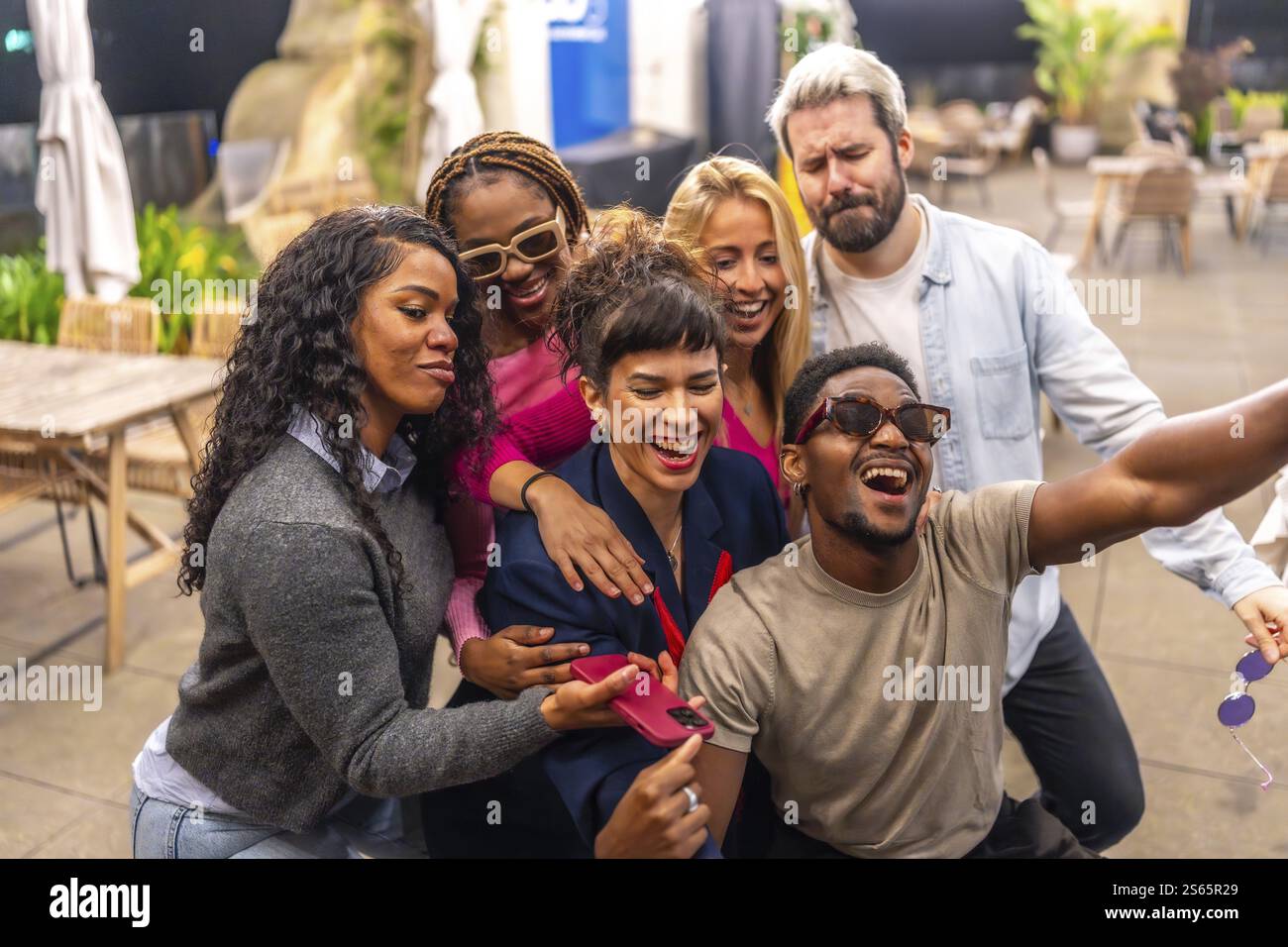 Happy group of multiracial friends taking selfie at night party in the ...