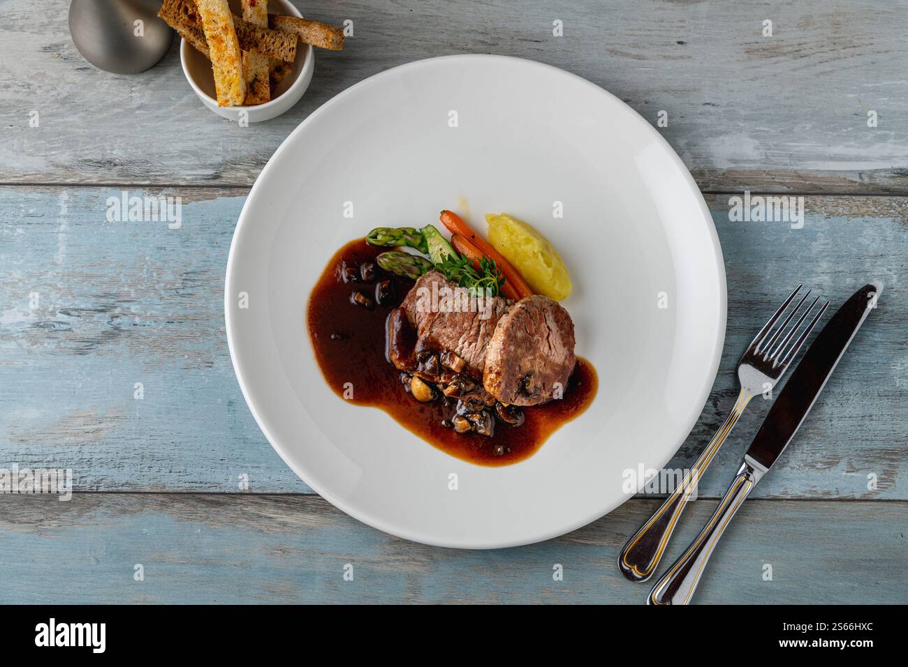 Grilled beef tenderloin with Demi glace sauce with grilled vegetables on a white porcelain plate Stock Photo