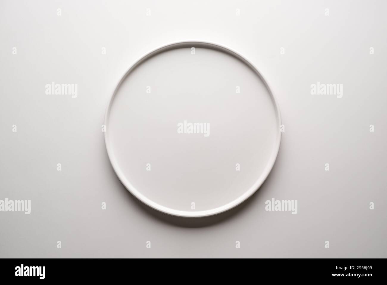 Top view of empty ceramic white plate on white background Stock Photo