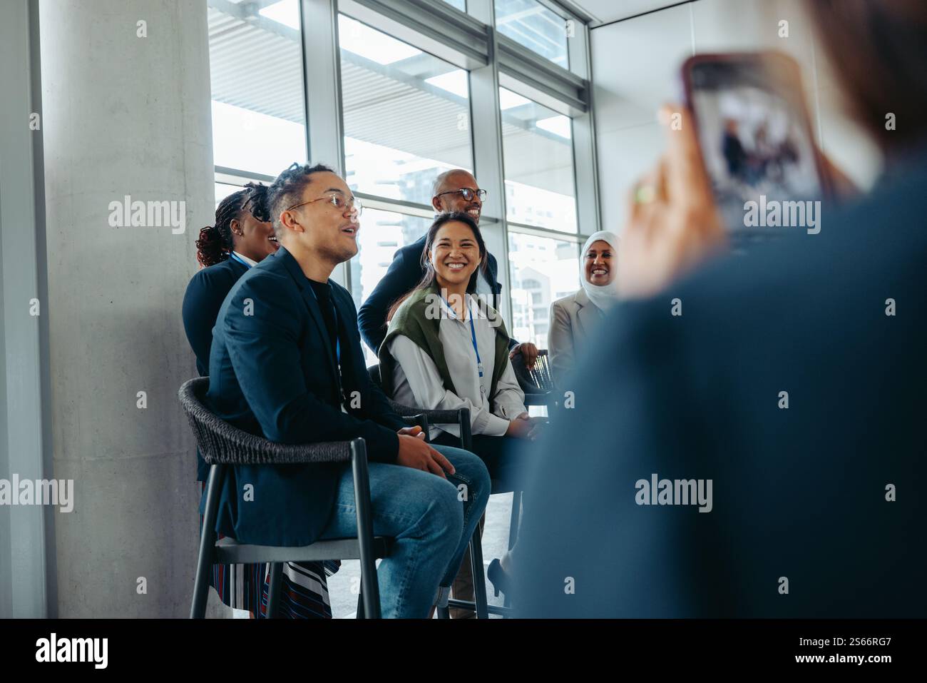 Male speaker interacting with audience during a business event while being filmed. The atmosphere is professional and energized. Stock Photo