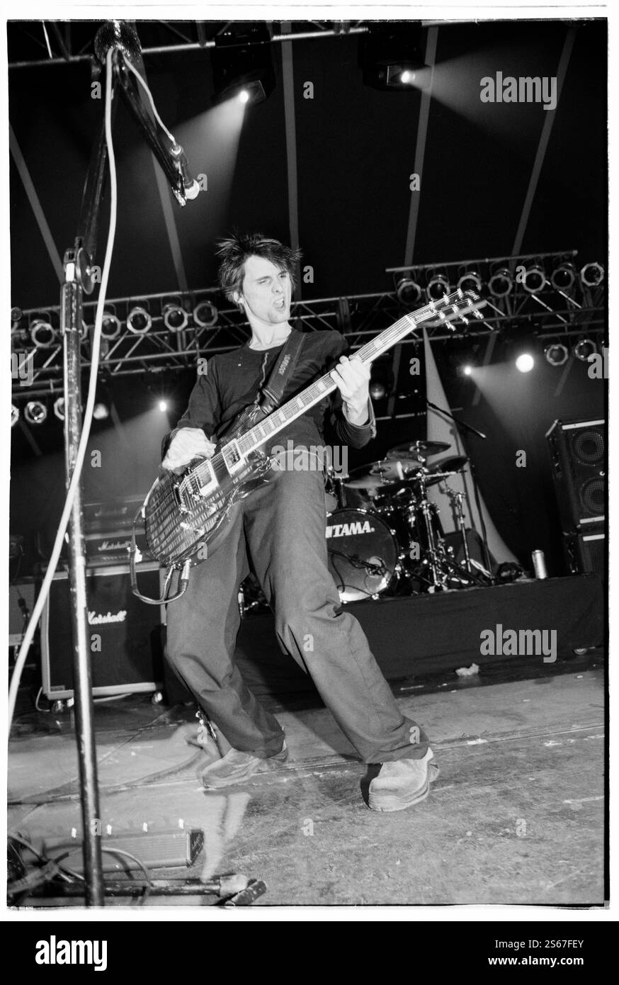 MUSE, YOUNG, READING FESTIVAL, 2000: An early career picture of singer songwriter Matt Bellamy from the English rock band Muse band playing live on the Melody Maker Stage with their debut album 'Showbiz' at Reading Festival, Reading, UK on 25 August 2000. Photo: Rob Watkins. INFO: Muse is a British rock band formed in 1994, known for their electrifying performances and genre-blending sound, fusing alternative rock, electronic, and symphonic elements. With hits like 'Uprising' and Black Holes and Revelations, they became global rock icons. Stock Photo