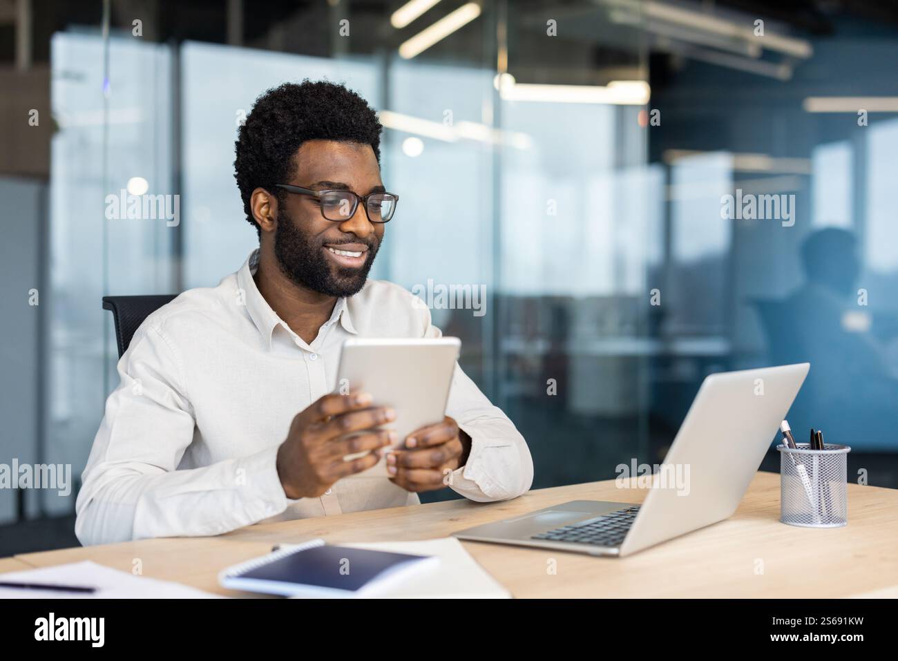 Smiling Working On Computer Successful businessman smiling working with laptop inside office at ...