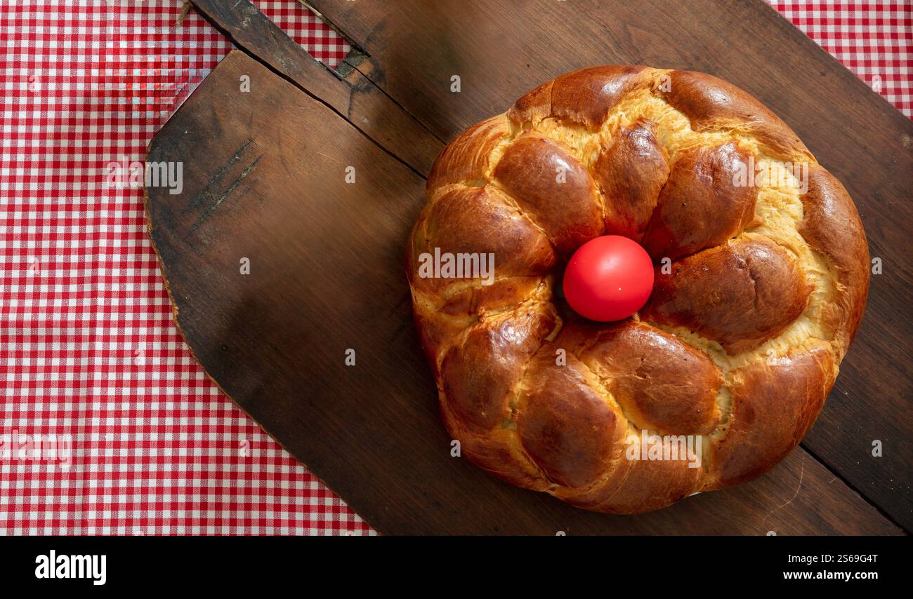 Easter bread, greek tsoureki braid and red easter eggs on table, top view Stock Photo