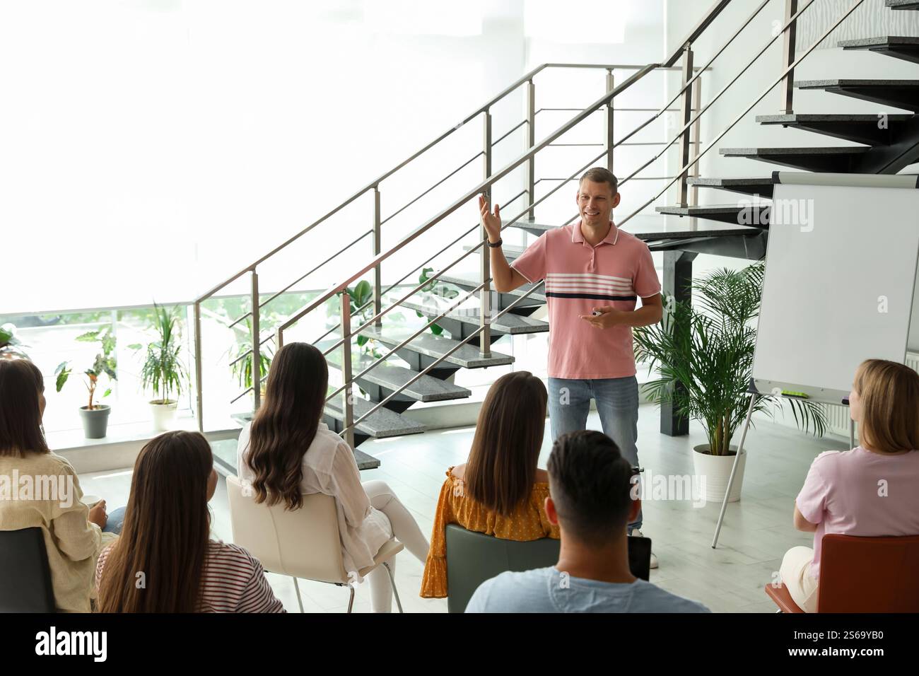 Male lecturer in casual clothes talking to audience indoors Stock Photo