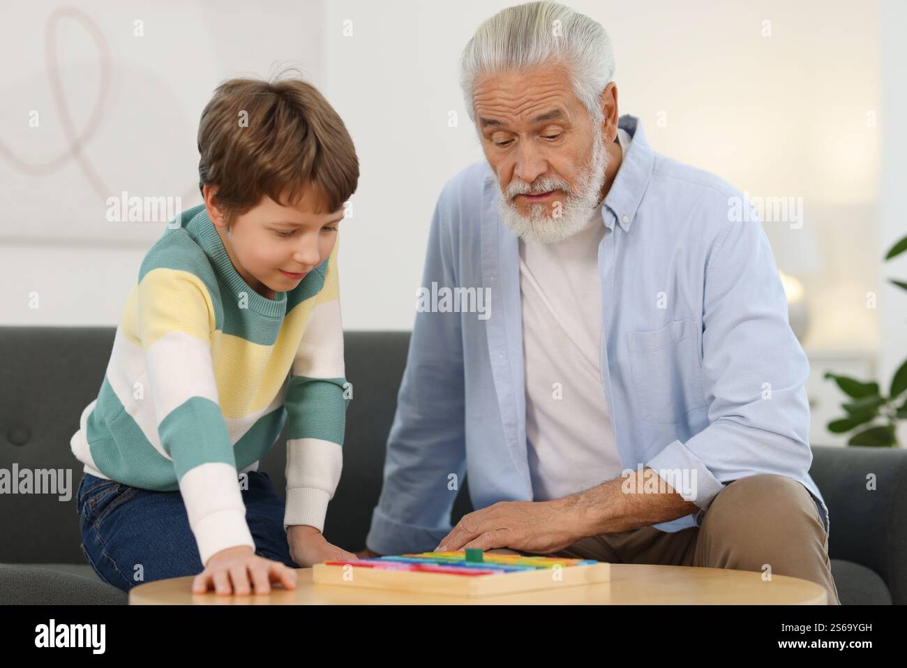 Man Playing Math Grandpa and his grandson playing with math game Times table tray at ...