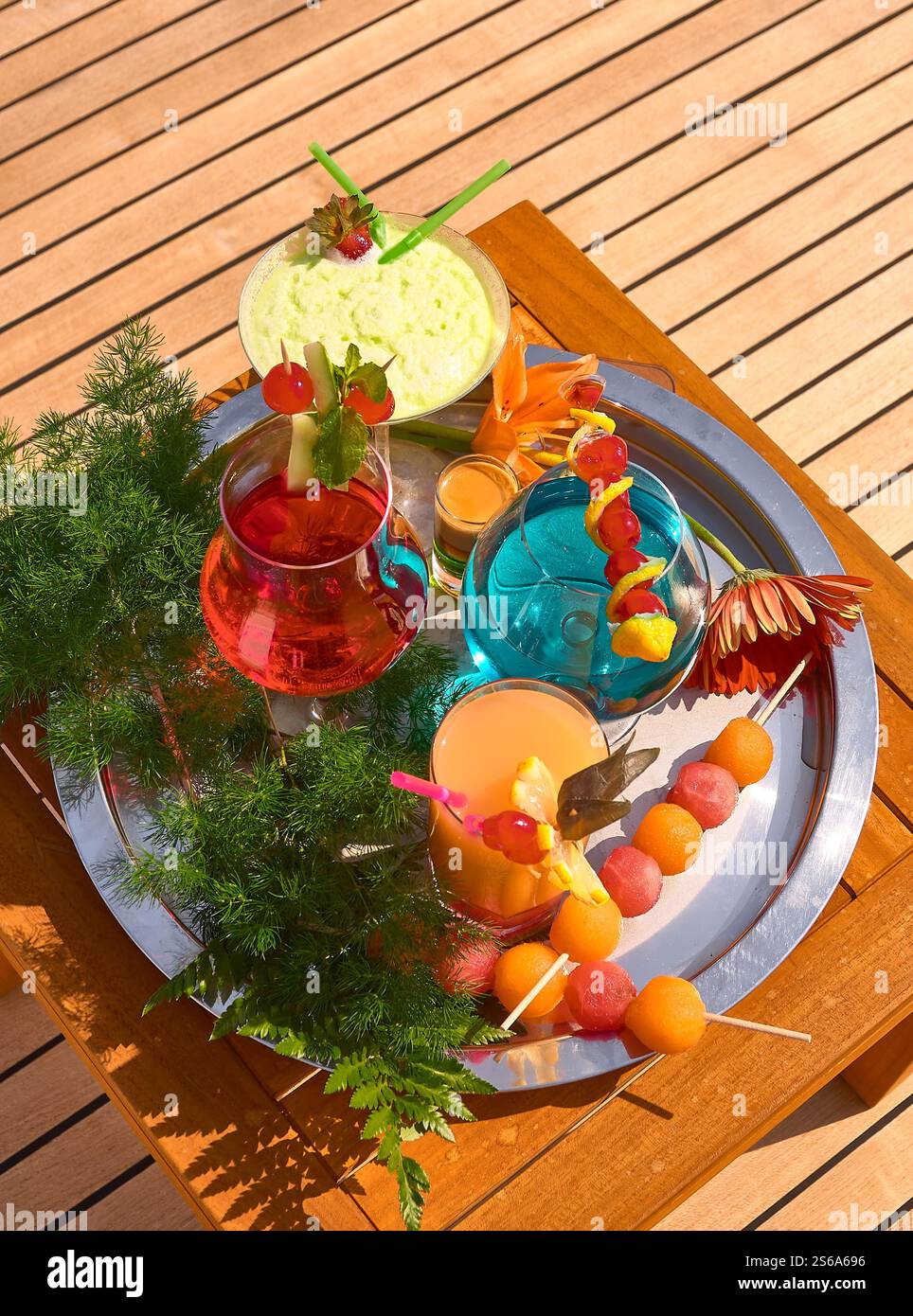 Colourful Refreshing Summer Cocktails with Fruit Garnish on an Outdoor Table Stock Photo