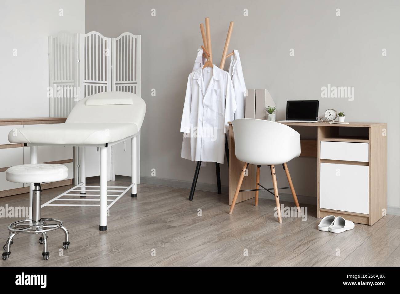 Interior of medical office with couch, clothes rack and doctor's ...