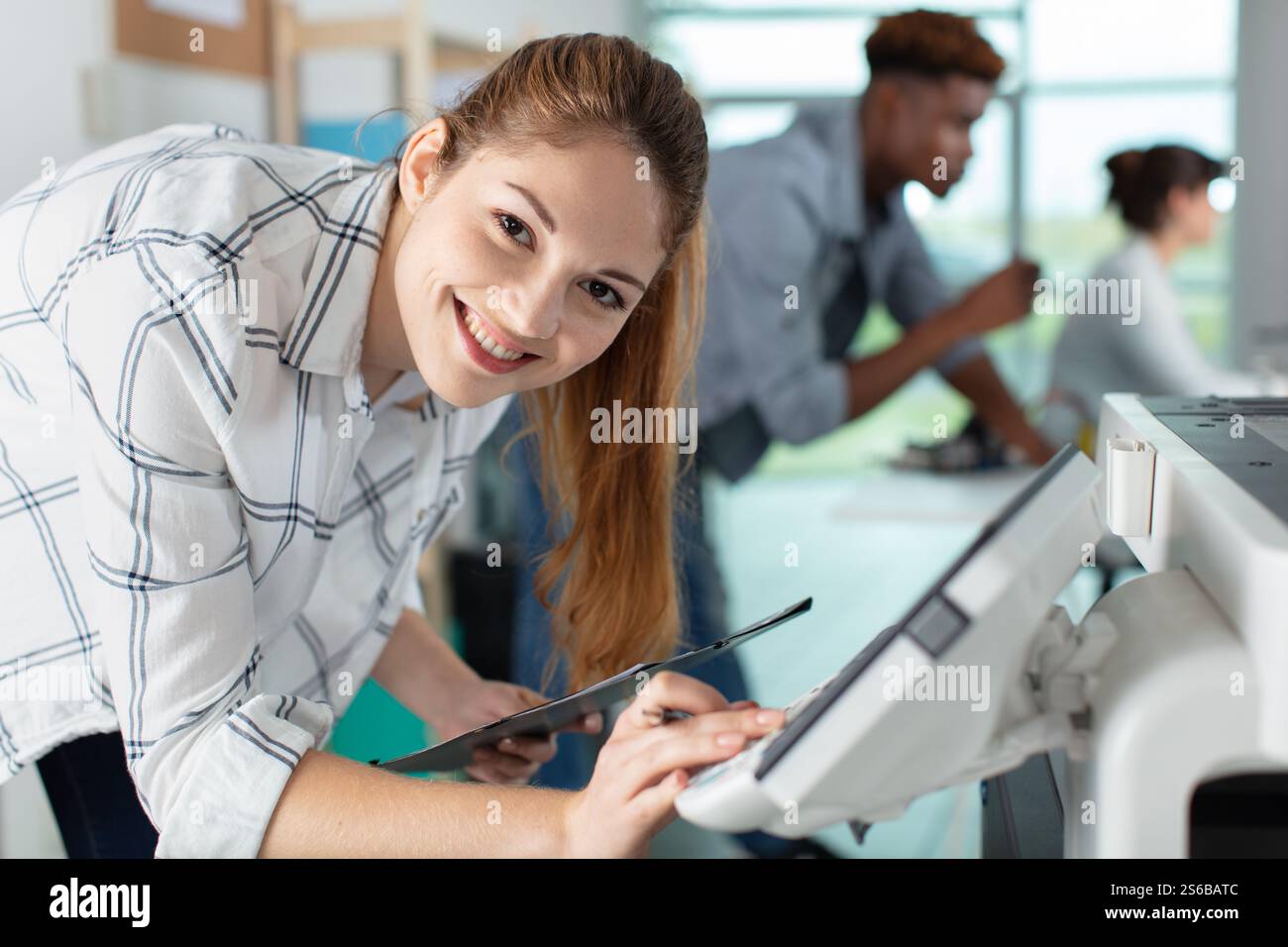 young female technician fixing printer Stock Photo