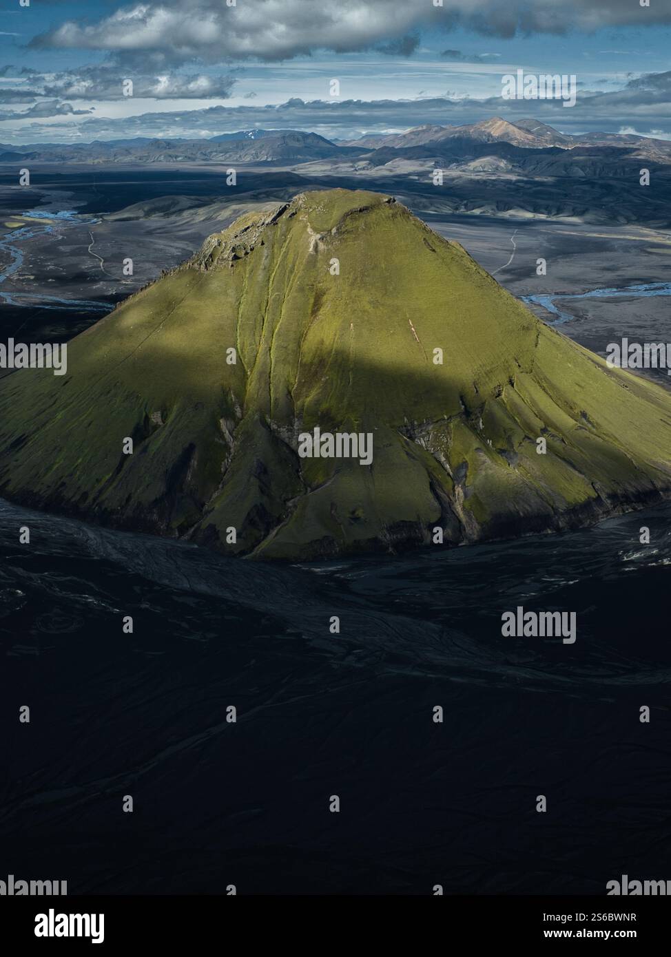 Aerial view of Maelifell volcano in Iceland’s Highlands, a striking green cone rising from black volcanic sands in a surreal and rugged landscape Stock Photo