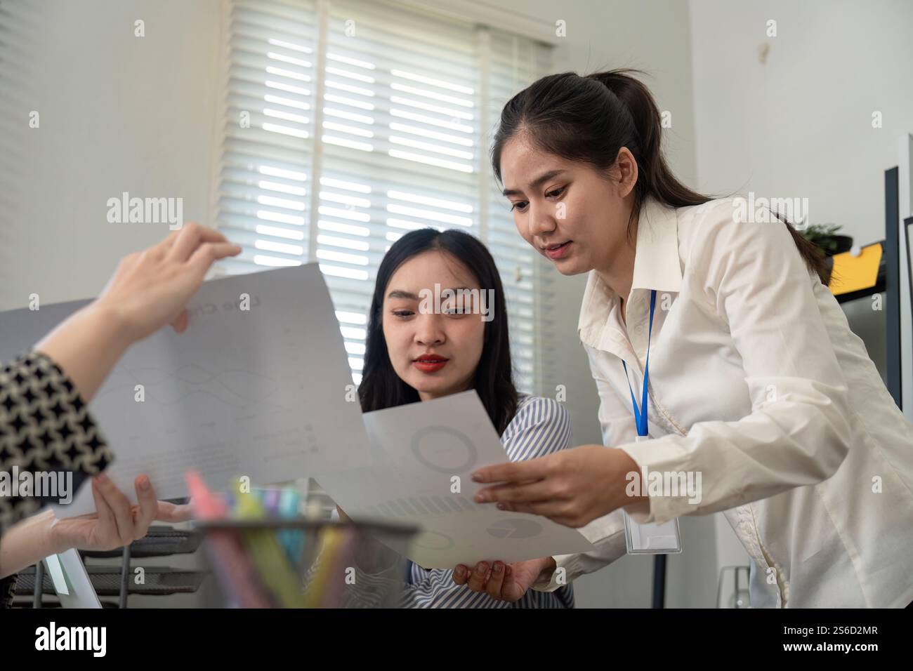 Business team analyzing data reports and collaborating in a modern office Stock Photo
