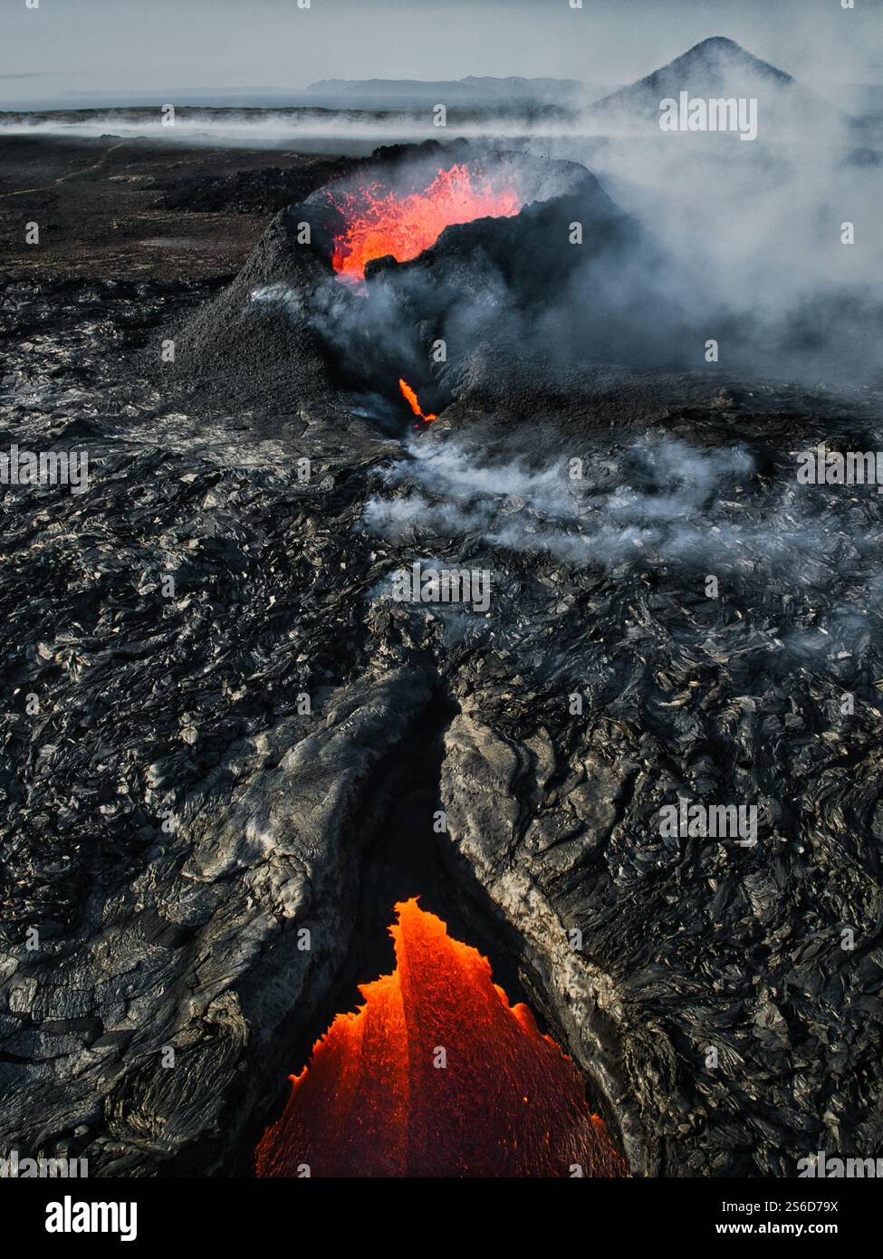 Aerial view of a volcanic eruption in Iceland, with molten lava flowing from the crater, creating a dramatic and fiery volcanic landscape Stock Photo