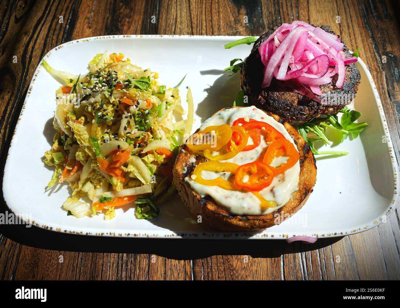 Open-faced vegan burger with pickled onions, peppers, and slaw on the side. - Smartphone Captured Stock Image