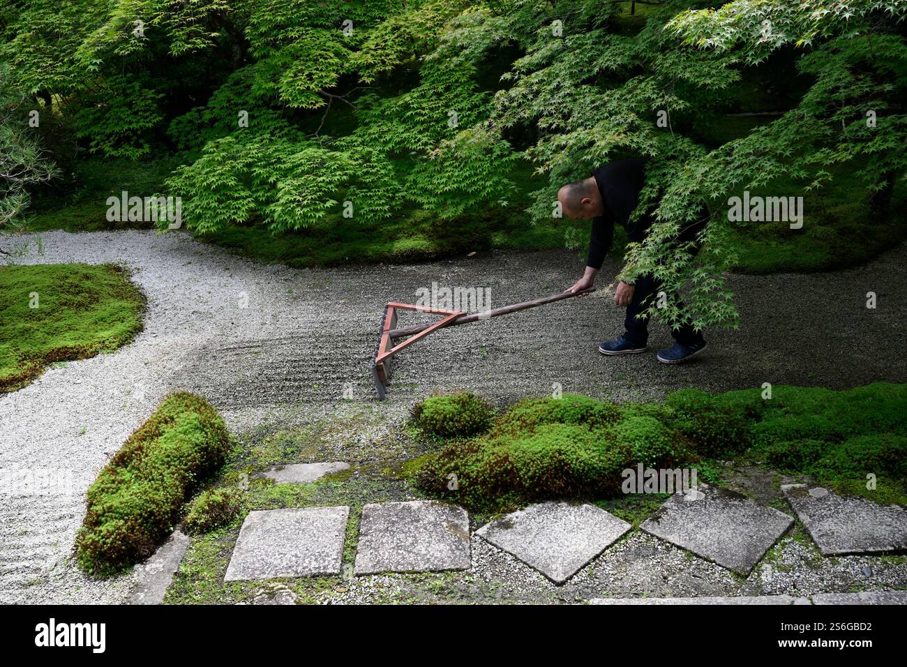 Buddhist monk raking the Zen garden of Tenjuan in the Nanzen-ji complex ...