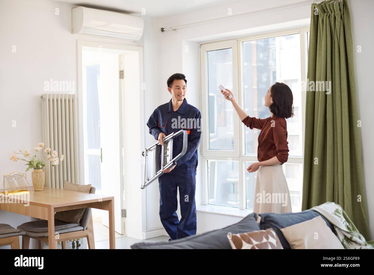 Handyman fixing the air conditioner Stock Photo