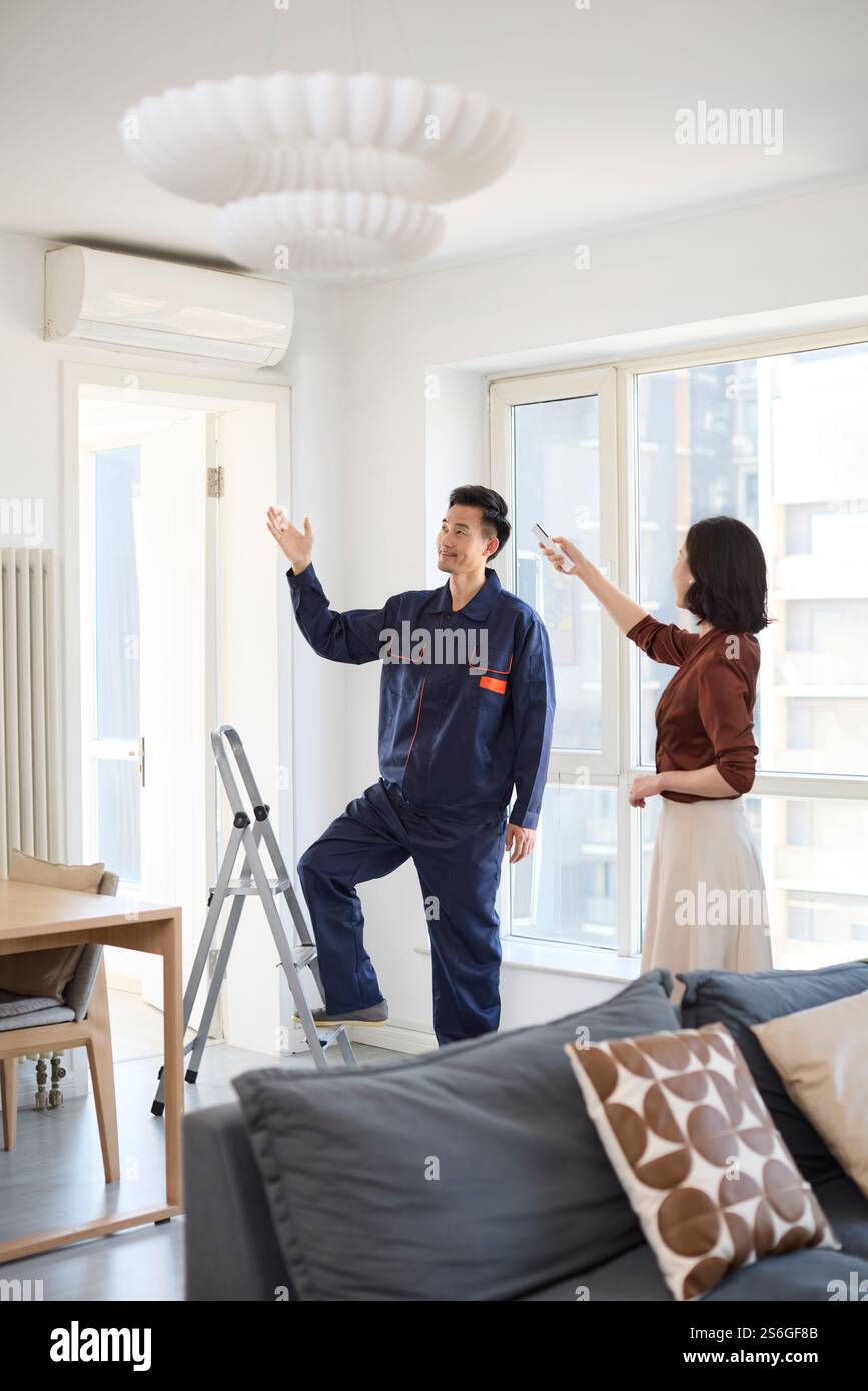Handyman fixing the air conditioner Stock Photo