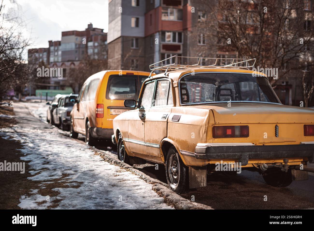 An old yellow Soviet car in the courtyard of a residential building ...