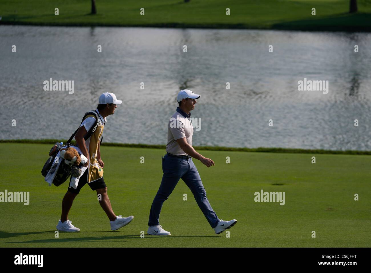 Rory McIlroy of Northern Ireland and his caddie walks towards 9th green