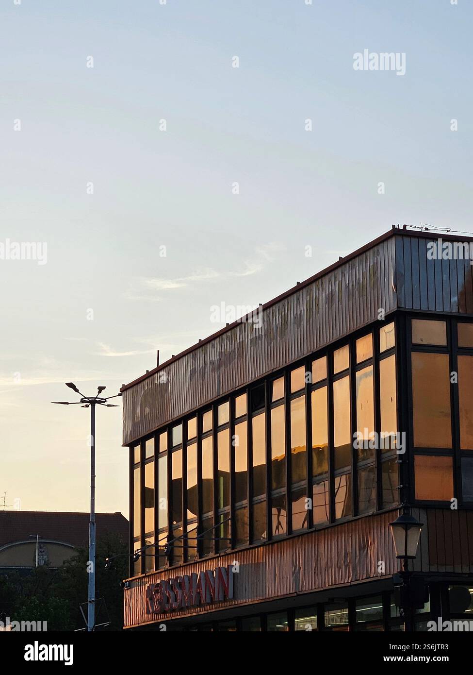 The sunset caught in the glass wall - old Rossmann store in Gdańsk Stock Photo