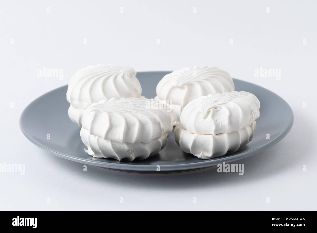 White marshmallows on gray plate on white background Stock Photo