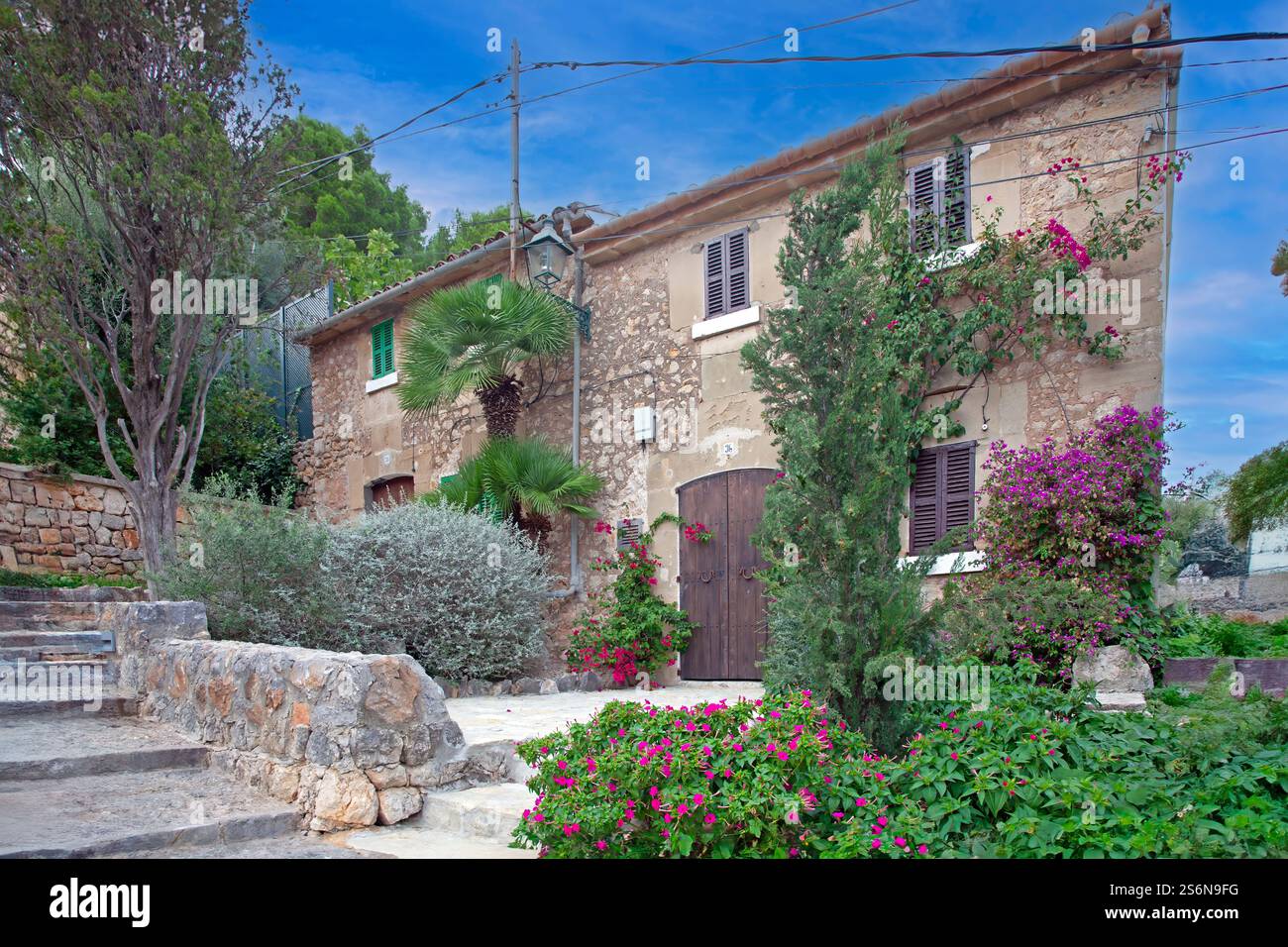 Rustic Mediterranean stone house with lush greenery in Mallorca during ...
