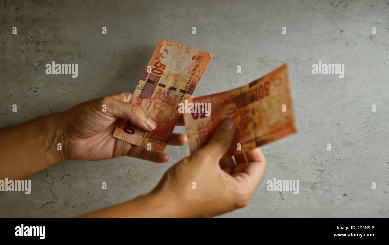 Hands holding and exchanging south african rand banknotes against a ...