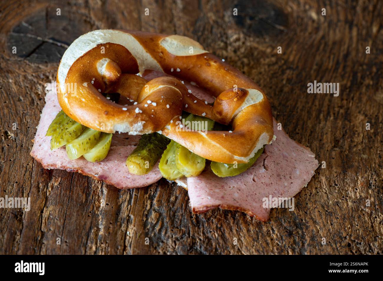 Leberkäse in a pretzel on wood Stock Photo