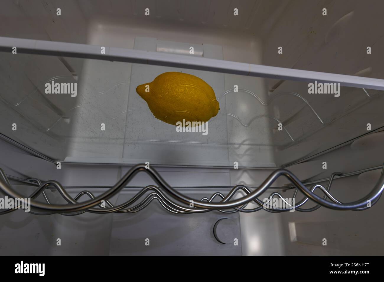 Yellow lemon in an empty fridge, empty shelves and lack of food, hunger and poverty in Europe and USA Stock Photo