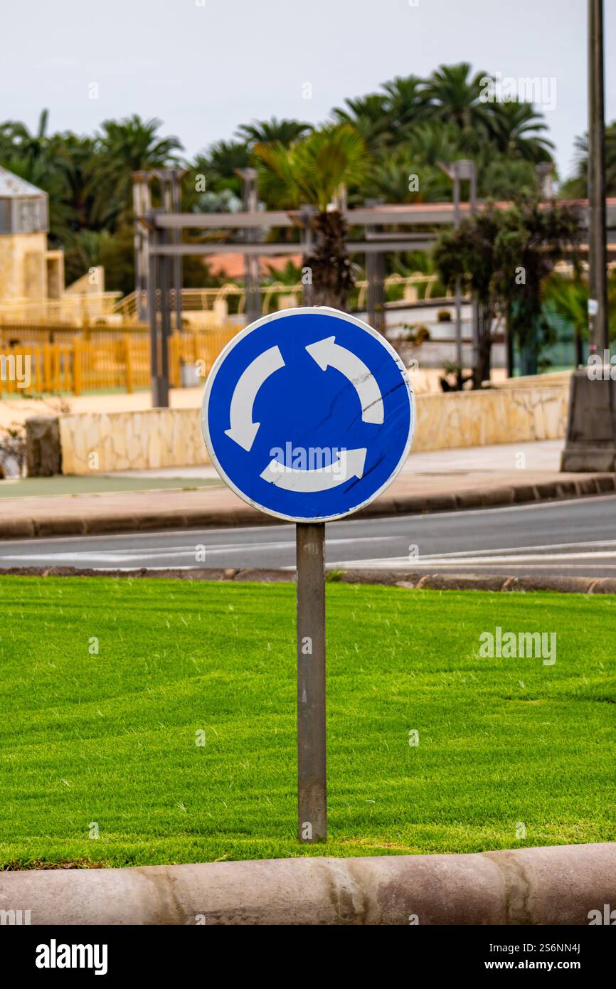 A blue sign with a white arrow pointing to the right. The sign is on a ...