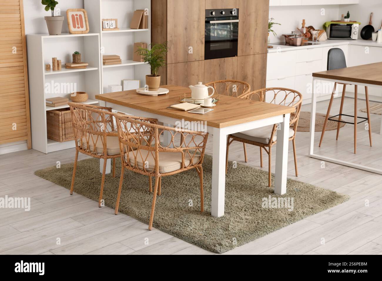 Interior of cozy kitchen with dining table and shelf units Stock Photo ...