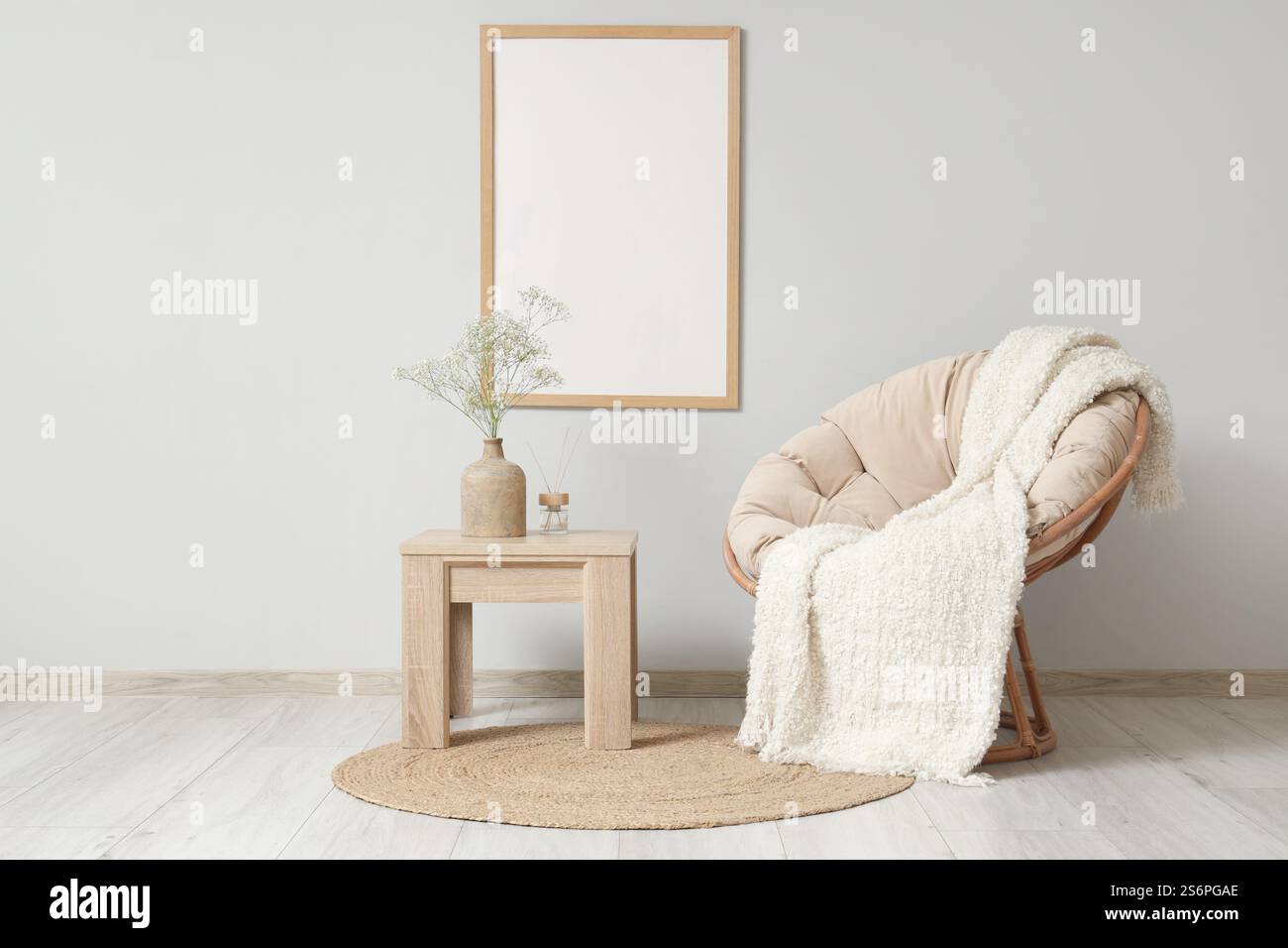 Coffee table with gypsophila flowers in vase and armchair in living ...