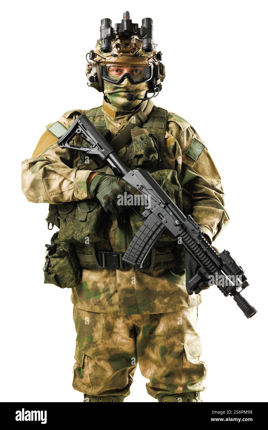 A military soldier wearing camouflage, holding a rifle, and dressed in full tactical equipment. The individual is also wearing advanced helmet and nig Stock Photo