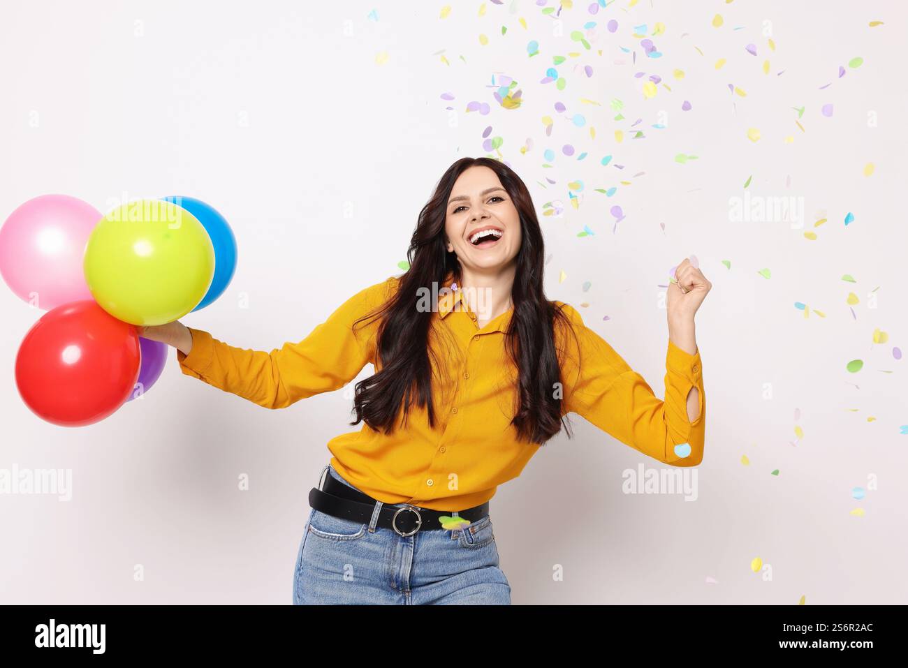 Happy Woman With Colorful Balloons Under Falling Confetti On White happy-woman-with-colorful-balloons-under-falling-confetti-on-white