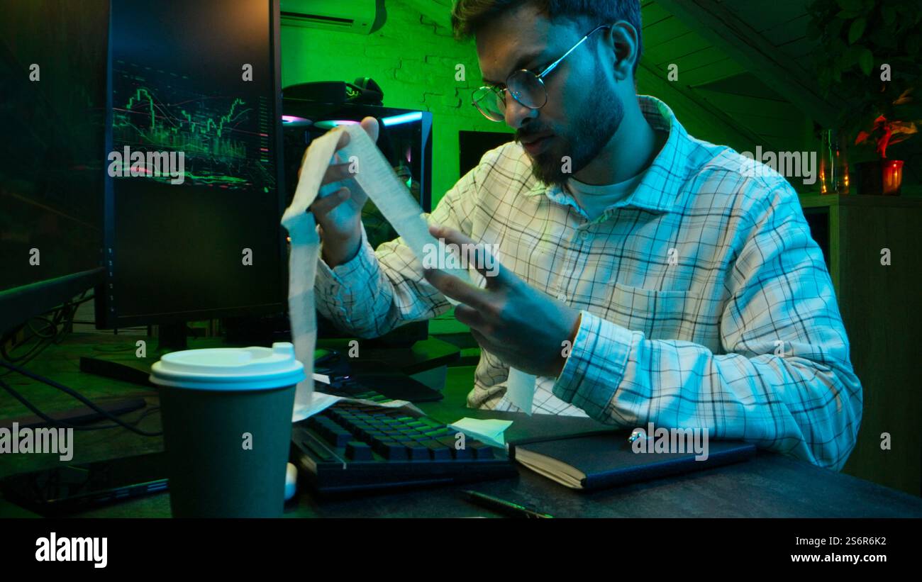 Caucasian focused man programmer checking coding guy coder male professional digital engineer IT support drinking coffee typing working on desktop Stock Photo